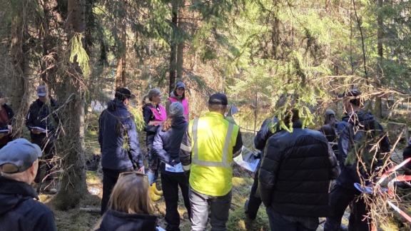 Metsäammattilaisia metsässä kuuntelemassa BSAG:n vesistöammattilaisia.